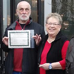 President Sue Scott, key in hand; Bob Jones with the title.